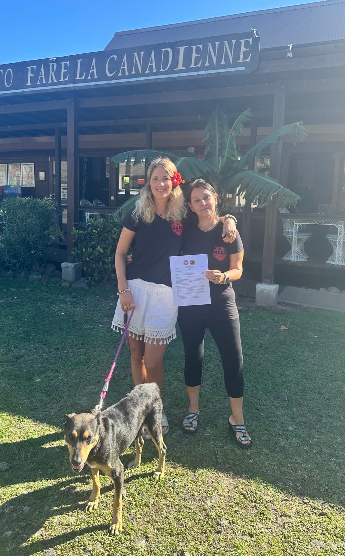 Fanny et Nancy Tourangeau, présidente de SCAT, tenant la convention de partenariat signée, accompagnées d'un chien